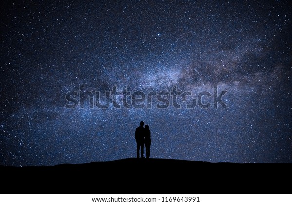 The man and woman standing on the sky with\
stars background