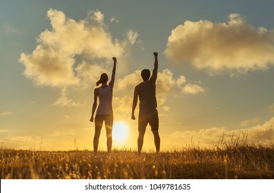 Man And Woman Standing Strong With Fist In The Air. Super Hero Concept. 