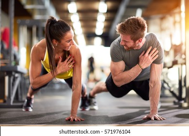 Man and woman strengthen hands at fitness training - Shutterstock ID 571976104