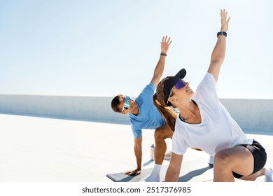 A man and a woman stretch outdoors, reaching upward during a sunlit exercise routine.

 - Powered by Shutterstock