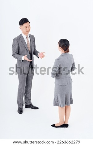 Man and woman in suits facing each other