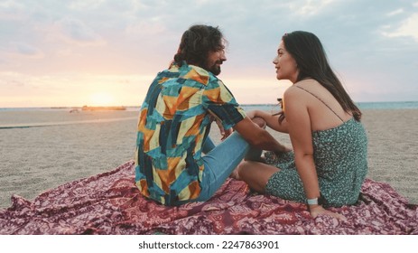 Man and woman talking to each other on the beach at sunrise - Powered by Shutterstock