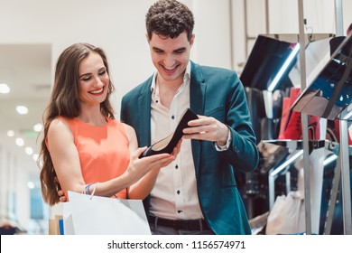 Man And Woman Thinking About Buying Pair Of Blue Shoes