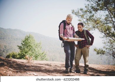 Man and woman Traveler with backpack on the mountain. - Shutterstock ID 623202488