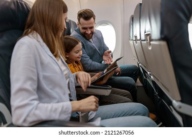 Man and woman traveling with daughter on airplane - Shutterstock ID 2121267056