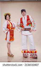 Man and woman in Ukrainian folk costume on a white background. A man in trousers, a folk shirt. Woman in red hat - Shutterstock ID 2136510407
