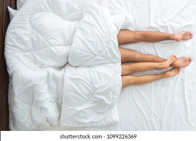 The man and woman under blanket laying on the bed. view from above