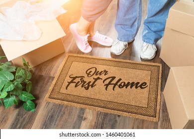 Man and Woman Unpacking Near Our First Home Welcome Mat, Moving Boxes and Plant.