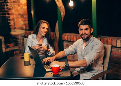 Man And Woman Using Laptop Computer Outdoor In Backyard Night Scene