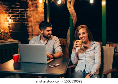 Man And Woman Using Laptop Computer Outdoor In Backyard Night Scene