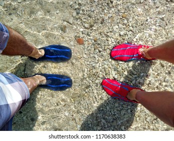 Man And Woman Using Splasher Aqua Water Shoes In The Rocky Sea