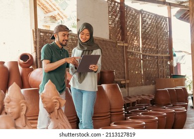 Man and woman in veil using tablet at pottery stall - Powered by Shutterstock