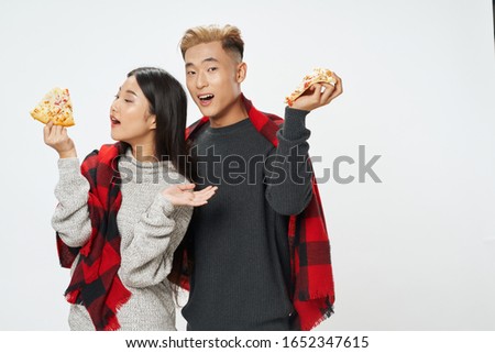Man and woman warm clothes and a piece of pizza food