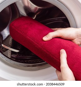 Man Or Woman Washes Red Bath Mat. Washing Carpet In Washing Machine