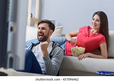 Man and woman watching tv on couch