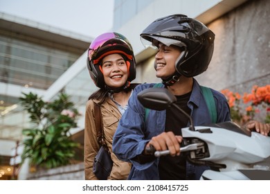 a man and woman wearing helmets riding a motorcycle - Shutterstock ID 2108415725