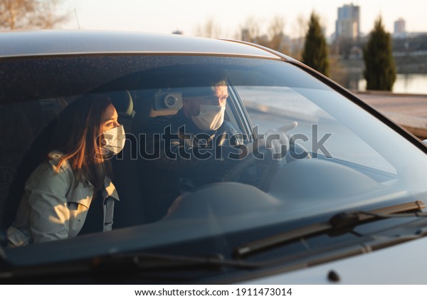 A man and a woman
wearing medical masks and rubber gloves to protect themselves from
bacteria and viruses while driving a car. masked men in the car.
coronavirus, covid-19.