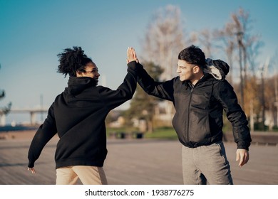 A man and a woman were resting outside, taking a break. They hit each other's hands. Training in a park in the city center. Healthy lifestyle. Outdoor sports activities. - Powered by Shutterstock