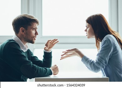 Man And Woman At Work Desk Chatting Conference To Work Colleague