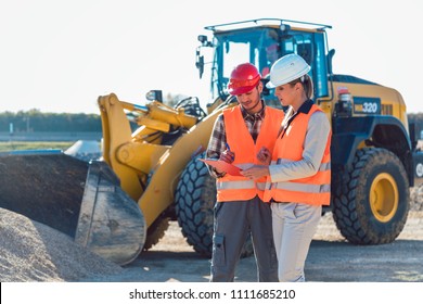 Man and woman worker on construction site talking