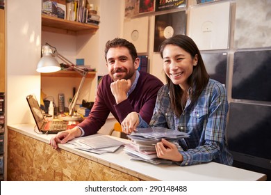 Man and woman working behind the counter at a record shop