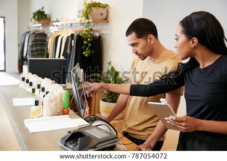 Man and woman working behind the counter in a clothing store