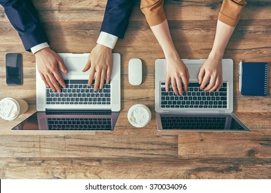 Man And Woman Working On Their Computers. The View From The Top. Two Laptops, Two Persons.