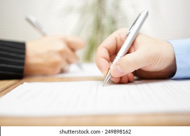 man and woman writing on document