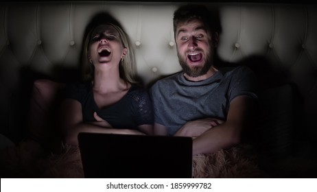 Man And Woman, Young Couple Watching Funny Movie On Laptop In Bed Before Going To Bed