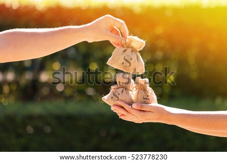 A man and a women hands hold a money bags in the public park for loans to planned investment in the future concept.