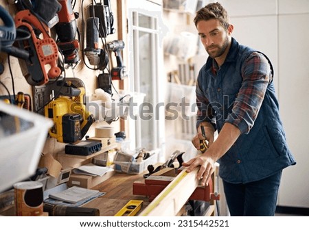 Man, wood and tape measure for construction, home development and building renovation. Carpenter, maintenance employee and male repairman worker on a contractor job of builder working in house