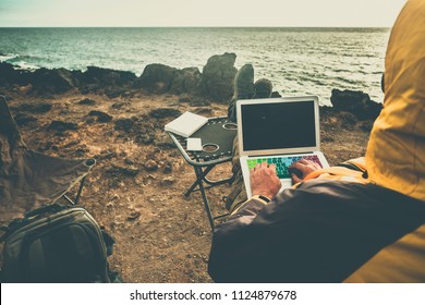 man at work in alternative office using laptop and smartphone to connect with internet and share things with the office - traveler concept digital nomad lifestyle all around the world