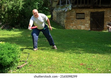 A Man In Work Clothes Playing Frisbee