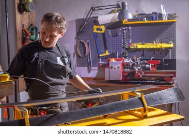 A Man In Work Clothes Repairman In The Workshop Ski Service Repairing The Ski