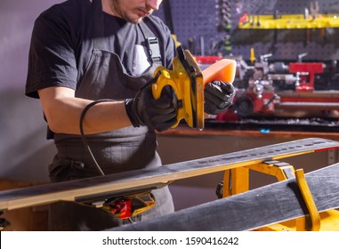 A Man In Work Clothes Repairman In The Workshop Ski Service Repairing The Ski