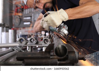 Man Work In Home Workshop Garage With Angle Grinder, Goggles And Construction Gloves, Sanding Metal Makes Sparks Closeup, Diy And Craft Concept