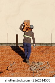 Man work on roofing installing. Roof constructin. Bricklayer roof repair. House under construction. Workman renovates waterproofing roof of building. Carpenter construction worker carry pile of tiles.