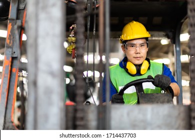 Man At Work. Professional Operation Engineering.  Young Worker Forklift Driver Wearing Safety Goggles And Hard Hat Sitting In Vehicle In Warehouse