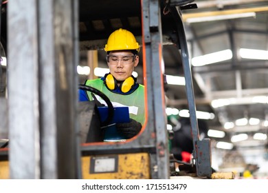 Man At Work. Professional Operation Engineering.  Young Worker Forklift Driver Wearing Safety Goggles And Hard Hat Sitting In Vehicle In Warehouse