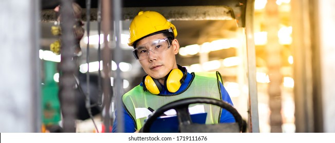 Man At Work. Professional Operation Engineering.  Young Worker Forklift Driver Wearing Safety Goggles And Hard Hat Sitting In Vehicle In Warehouse