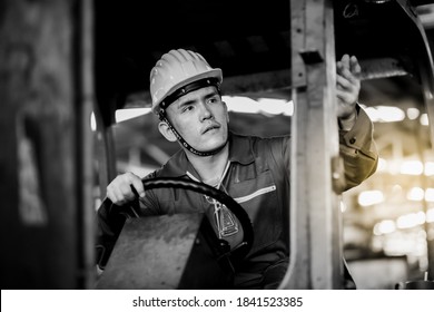 Man At Work. Professional Operation Engineering. Young Asian Worker Forklift Driver Wearing Safety Goggles And Hard Hat Sitting In Vehicle In Warehouse