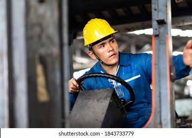 Man At Work. Professional Operation Engineering. Young Asian Worker Forklift Driver Wearing Safety Goggles And Hard Hat Sitting In Vehicle In Warehouse