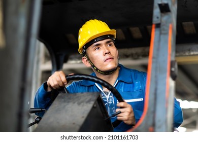 Man At Work. Professional Operation Engineering. Young Asian Worker Forklift Driver Wearing Safety Goggles And Hard Hat Sitting In Vehicle In Warehouse