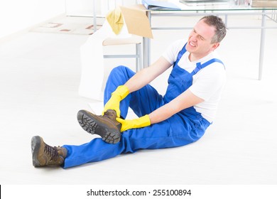 Man worker with ankle injury, concept of accident at work