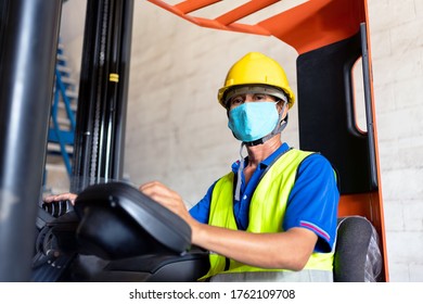 Man Worker Asian Forklift Driver With Protective Mask Working In Industrial Factory Or Warehouse.standard To Prevent Coronavirus COVID-19 Infection