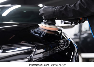 Man worker of car detailing studio removing scratches on car varnish - Powered by Shutterstock