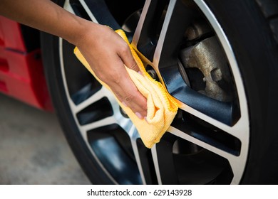 Man Worker Cleaning Car's Alloy Wheels On A Car Wash