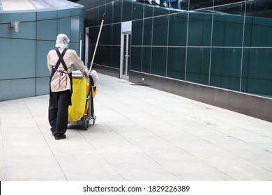 Man Worker With Corono Virus, Covid-19 Protect Working With Janitorial, Cleaning Equipment And Tools For Floor Cleaning.