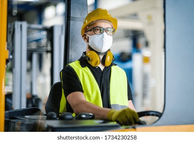 Man Worker Forklift Driver With Protective Mask Working In Industrial Factory Or Warehouse.