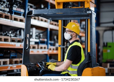 Man Worker Forklift Driver With Protective Mask Working In Industrial Factory Or Warehouse.